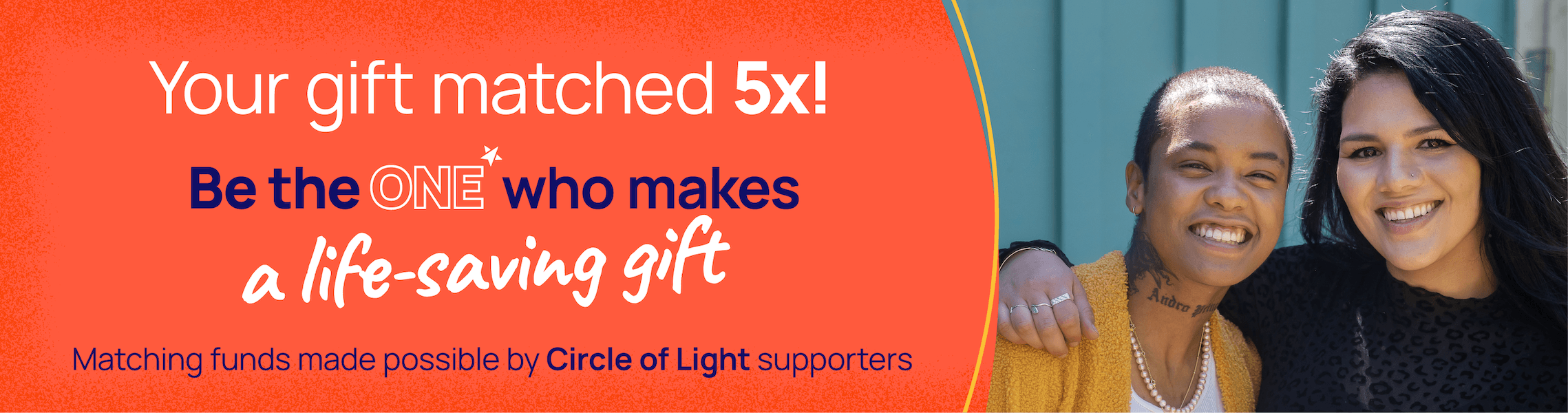 An LGBTQ+ young person in a white sweater and her mom in a purple sweater posing together and smiling at the camera. Be the one with your gift today.